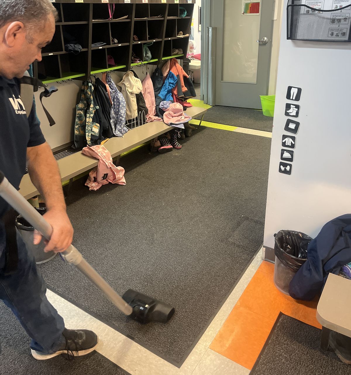 Technicien Expertise WY effectuant l'entretien d'un tapis d'hiver dans l'entrée d'un CPE